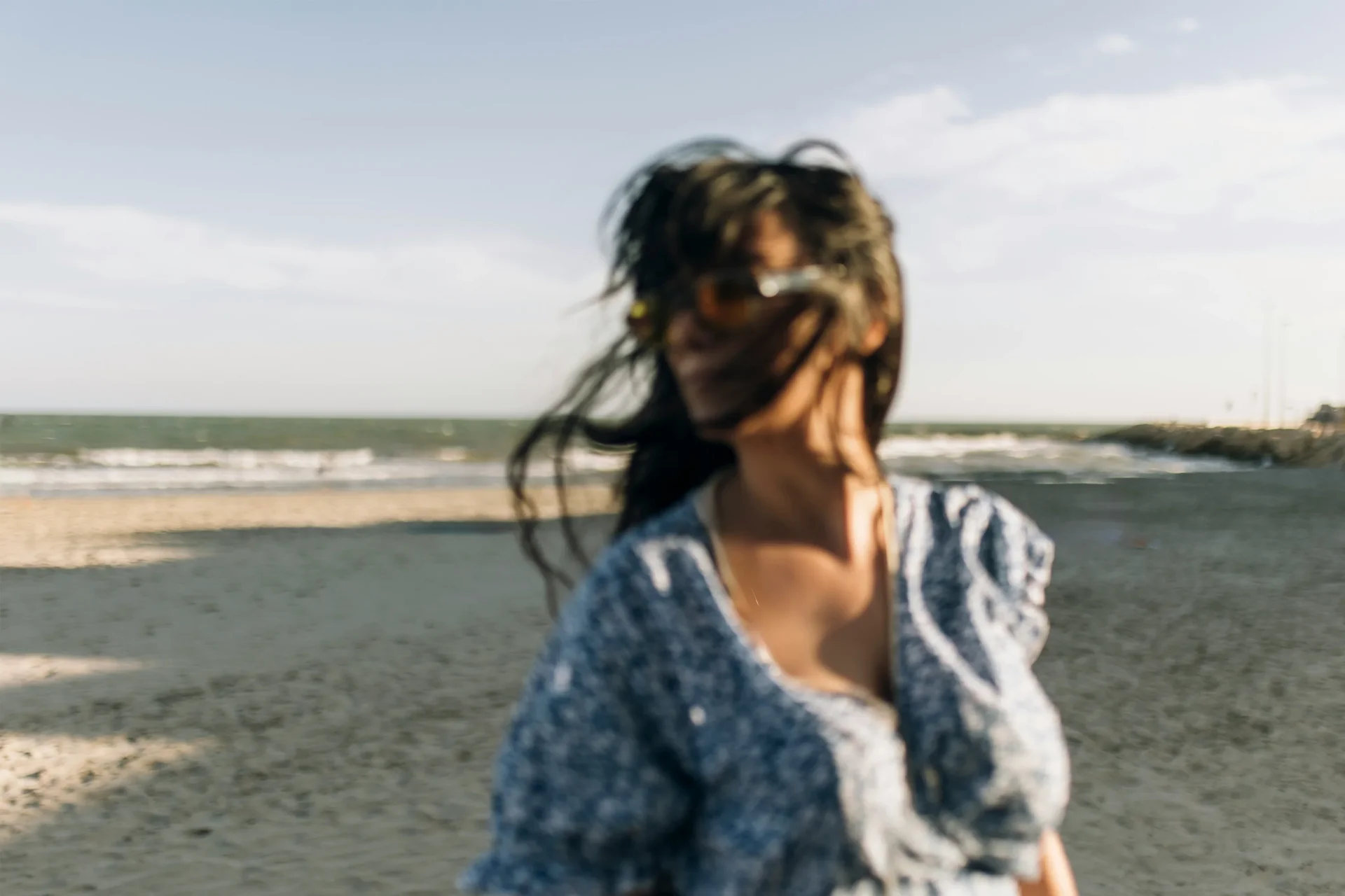 Een vrouw op het strand, met haar blik naar de horizon